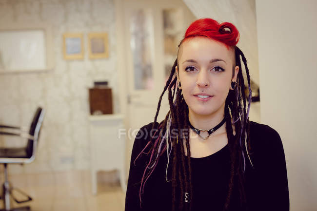 Portrait of female hairdresser in dreadlocks shop — Stock Photo
