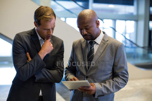 Geschäftsleute nutzen digitales Tablet am Flughafen — Stockfoto
