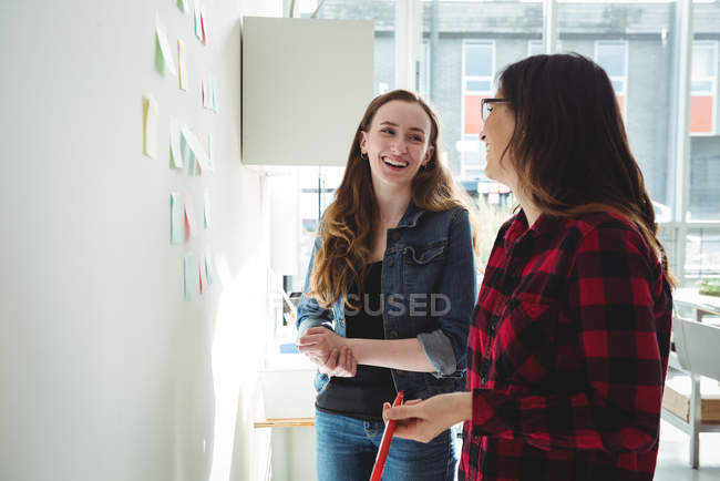 Happy business executives interacting with each other in office — Stock Photo