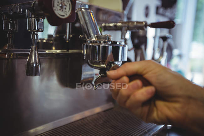 Waitress holding portafilter filled with ground coffee in cafe — Stock Photo