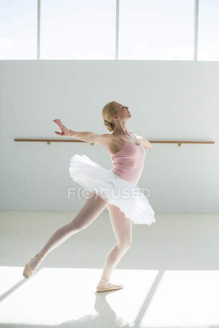 Балерина репетирует балетный танец в балетной студии — стоковое фото