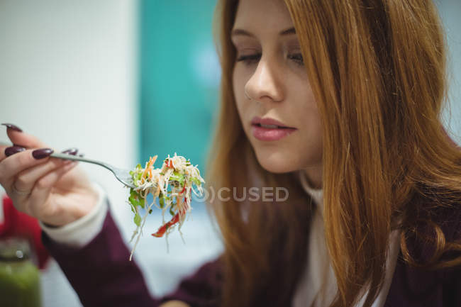 Крупный план красивой женщины, которая ест салат — стоковое фото