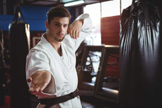 Karate player performing karate stance in fitness studio — Stock Photo