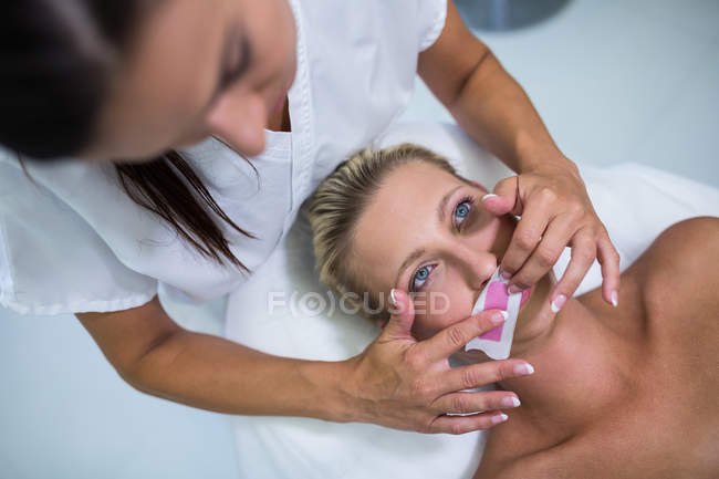 Frau lässt sich im Schönheitssalon die Gesichtsbehaarung entfernen — Stockfoto