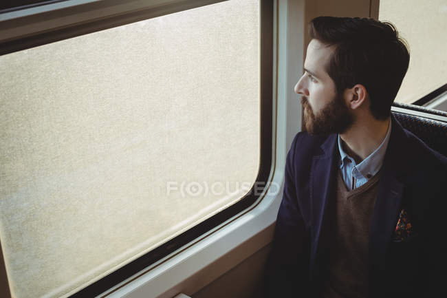 Продуманий бізнесмен дивиться через вікно поїзда — стокове фото