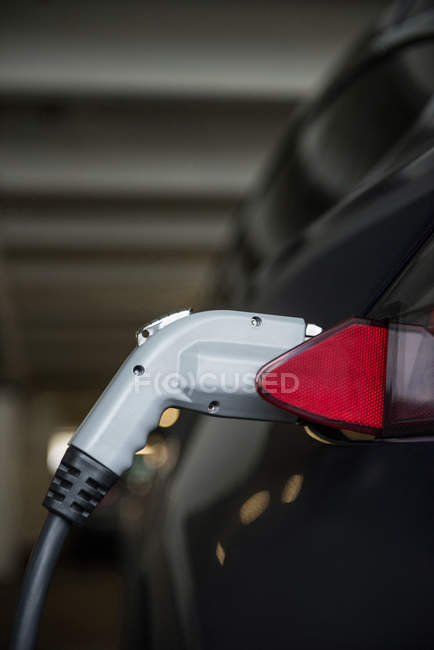 Close-up of car charging with electric car charger at charging station — Stock Photo