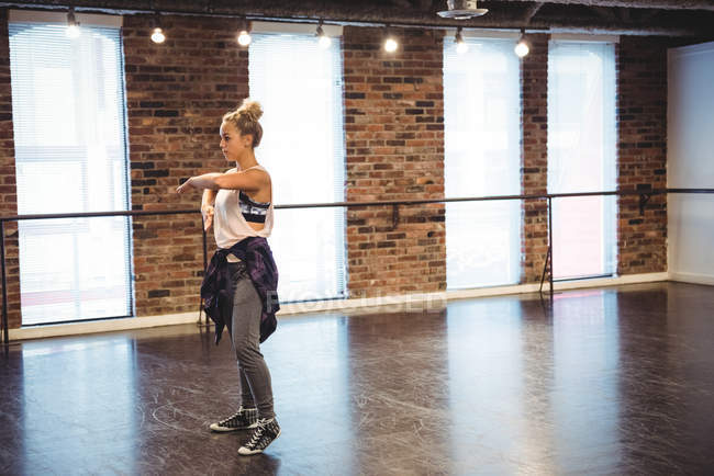 Mujer practicando un movimiento de baile en estudio de baile - foto de stock