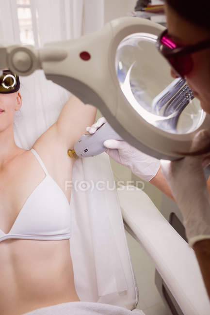 Paciente femenina que recibe tratamiento de depilación láser en clínica - foto de stock
