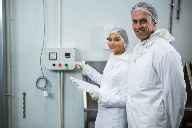 Retrato de técnicos manteniendo registro en portapapeles en fábrica - foto de stock
