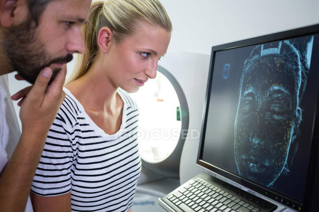 Mulher olhando relatório de varredura mri na tela do computador na clínica — Fotografia de Stock
