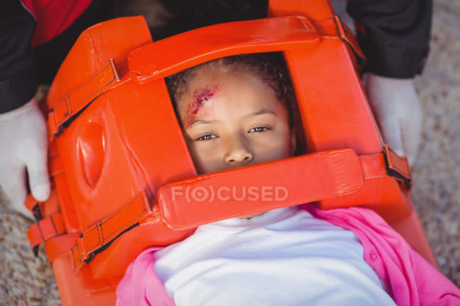 Menina ferida tratada por paramédico no local do acidente — Fotografia de Stock