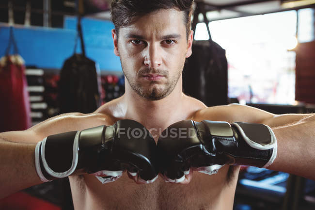 Portrait of boxer performing boxing stance in fitness studio — Stock Photo