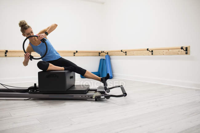 Woman exercising with pilates ring in fitness studio — Stock Photo