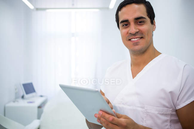 Retrato de dentista usando tablet digital na clínica — Fotografia de Stock