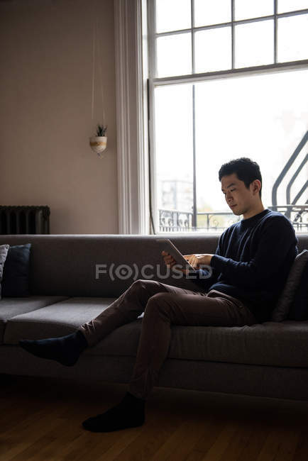 Mann nutzt digitales Tablet im heimischen Wohnzimmer — Stockfoto