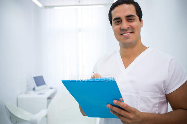 Портрет улыбающегося доктора с медицинской картой — стоковое фото