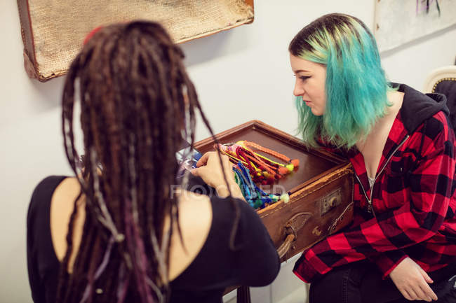 Proprietaria di un negozio femminile che interagisce con un cliente in un negozio di dreadlocks — Foto stock