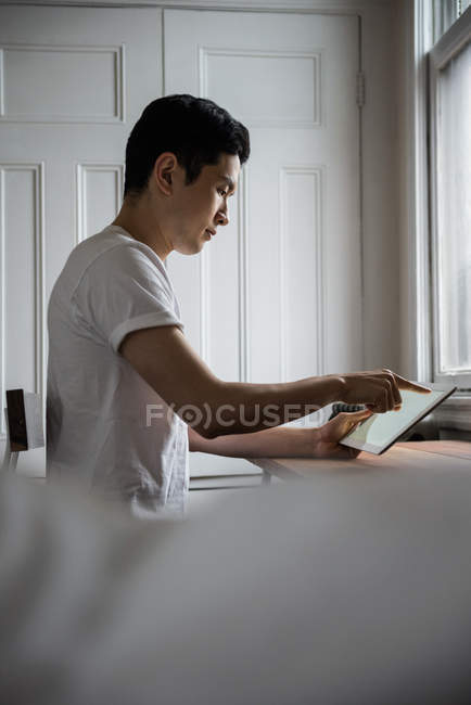 Людина використовує цифровий планшет у вітальні вдома — стокове фото
