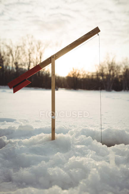 Gros plan de la canne à pêche dans un trou de glace dans un paysage enneigé — Photo de stock