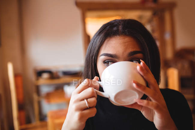 Mujer bebiendo café en la cafetería - foto de stock