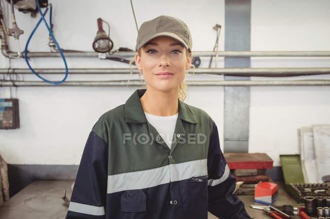 Retrato de bela mecânica feminina sorrindo na garagem — Fotografia de Stock