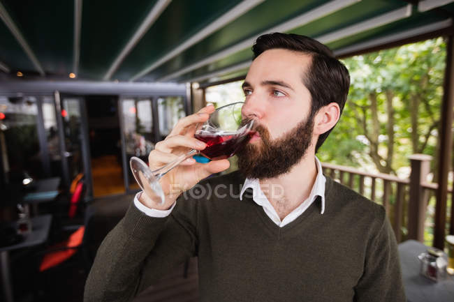 Close-up do homem tomando um copo de vinho no bar — Fotografia de Stock