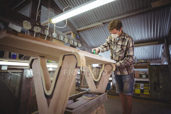 Hombre usando cepilladora modificada en taller de tabla de surf - foto de stock