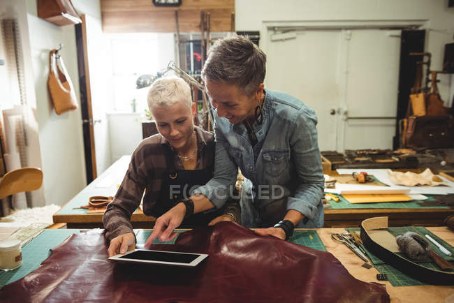 Mature craftswomen using digital tablet in workshop — Stock Photo