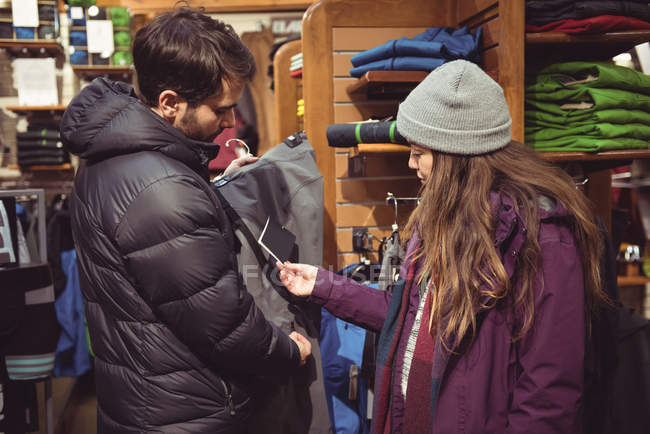 Paar sucht Kleidung gemeinsam in einem Bekleidungsgeschäft aus — Stockfoto