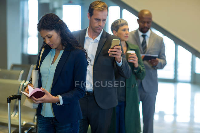 Business commuters esperando na fila no aeroporto — Fotografia de Stock