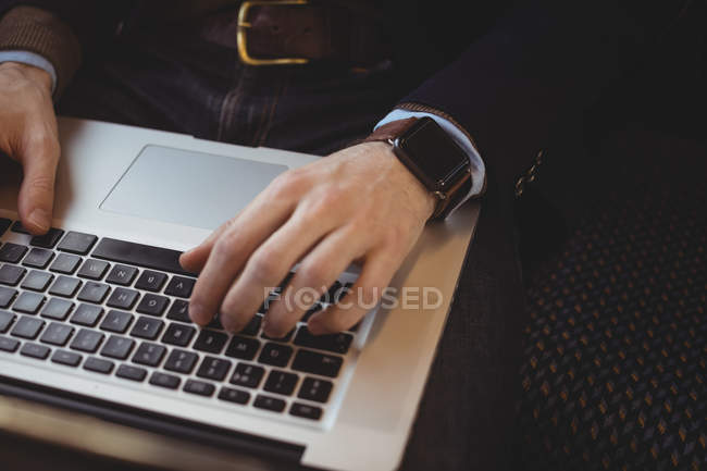 Mittelteil des Geschäftsmannes nutzt Laptop während Zugfahrt — Stockfoto