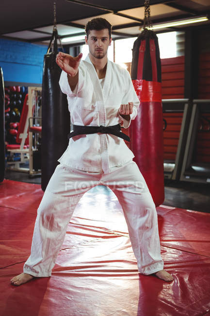 Portrait of karate player performing karate stance in fitness studio — Stock Photo