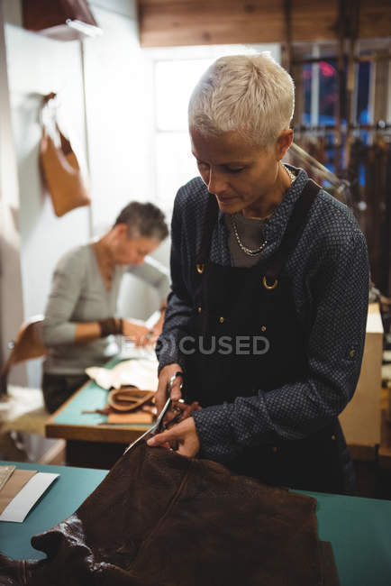 Atenta artesana de corte de cuero en el taller - foto de stock