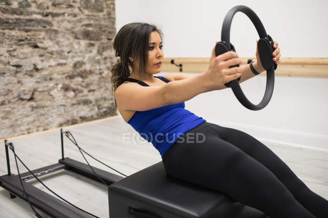 Femme faisant de l'exercice avec pilates anneau dans la salle de gym — Photo de stock