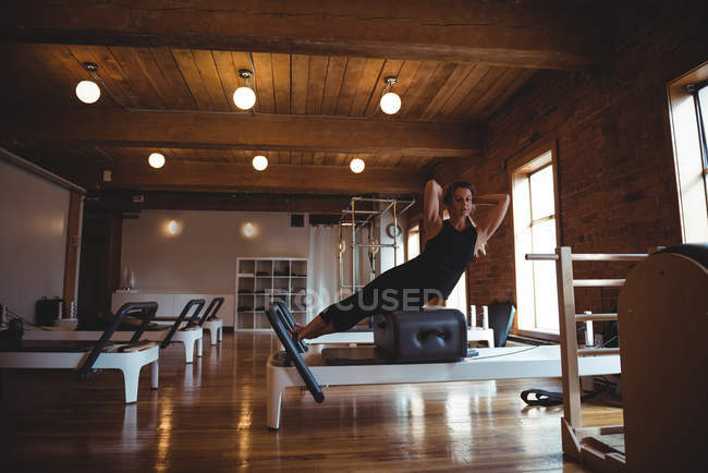 Healthy woman practicing pilates in fitness studio — Stock Photo