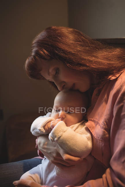 Madre baciare figlia bambino sulla testa, primo piano — Foto stock