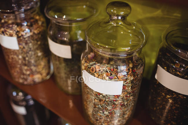 Close-up de vários frascos de especiarias dispostos na prateleira na loja — Fotografia de Stock