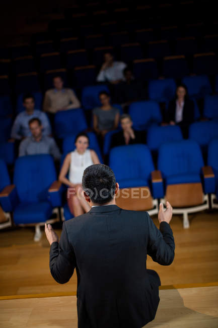 Vista posteriore del dirigente aziendale maschile che parla con i colleghi al centro congressi — Foto stock