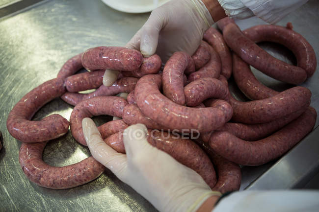 Primo piano della lavorazione delle salsicce da macellaio in fabbrica di carne — Foto stock