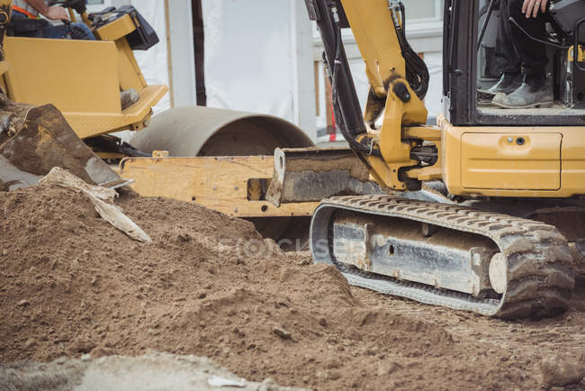 Close-up of bulldozer levelling mud at construction site — Stock Photo