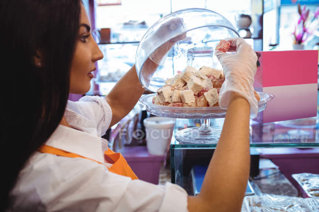 Femmina negoziante organizzare dolci turchi al banco in negozio — Foto stock