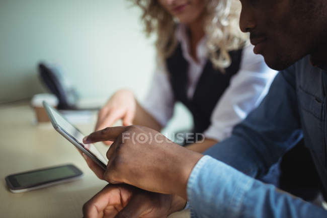 Close-up de executivos de negócios discutindo sobre tablet digital no escritório — Fotografia de Stock
