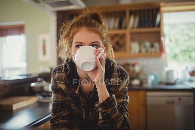 Bella donna che prende il caffè in cucina a casa — Foto stock