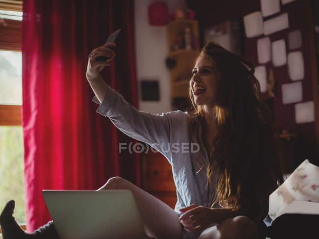 Belle femme prenant un selfie à la maison — Photo de stock