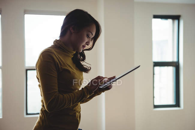 Femme utilisant une tablette numérique à la maison — Photo de stock
