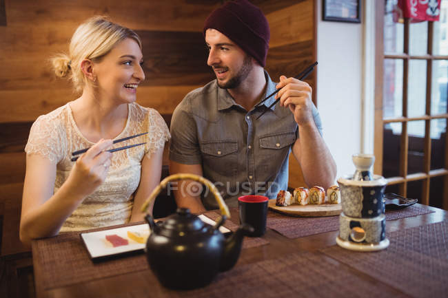 Sorrindo casal ter sushi no restaurante — Fotografia de Stock