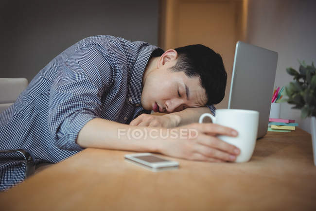 Executivo de negócios dormindo em sua mesa no escritório — Fotografia de Stock