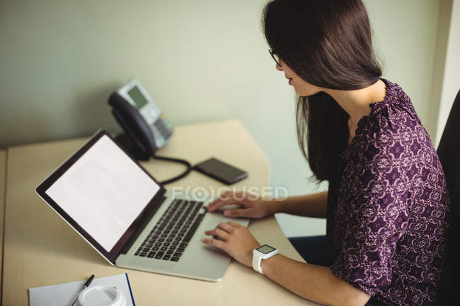 Empresária trabalhando no laptop no escritório — Fotografia de Stock