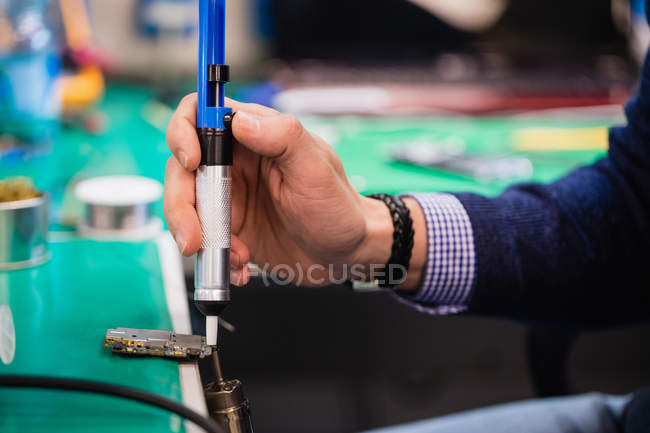 Close-up of man removing solder using solder sucker — Stock Photo