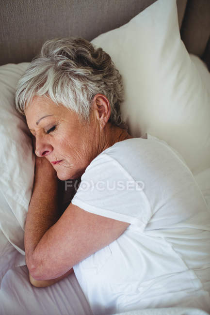 Senior mulher dormindo na cama no quarto em casa — Fotografia de Stock